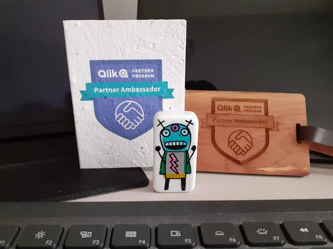 Qlik Hero Bot and Partner Ambassador logos.
