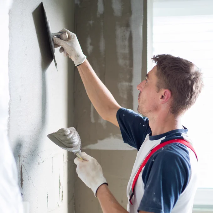 Someone plastering a wall