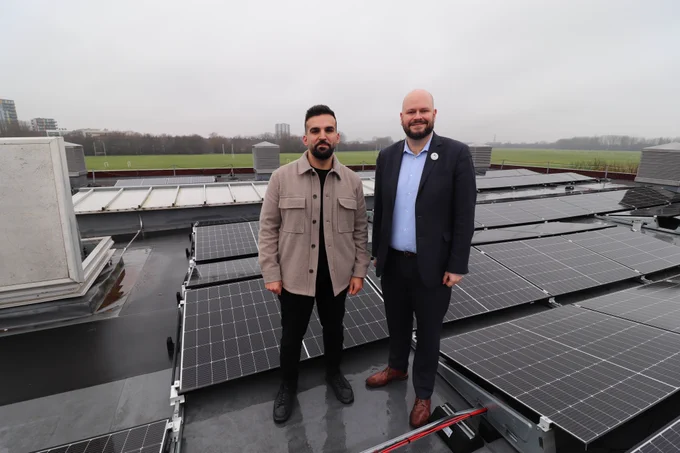 Mayor of Hackney Philip Glanville and Cllr Mete Coban stood on a roof with solar panels at Hackney Marshes Centre. 