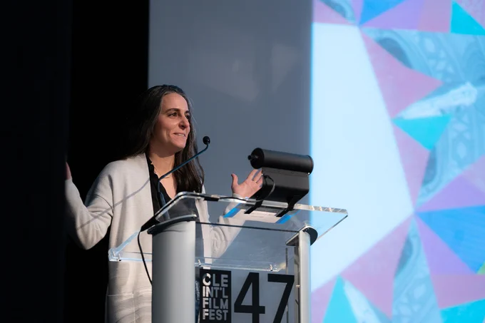 A photo of Sierra Urich standing at a podium on stage at the Cleveland International Film Festival.