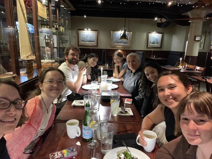 Faculty and students from the humanities program sitting around a dinner table with the guest lecturer.