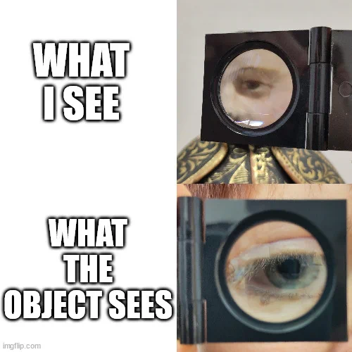 Two pairs of text on the left with a close up of an eye on the right. The upper half shows the text “What I see” and next to it a close up shot of the painted eye of a wooden sculpture, enlarged by a magnifying glass. On the bottom half is the text “What the object sees” with a picture of the same magnifying glass, this time with an enlarged human eye looking through it.