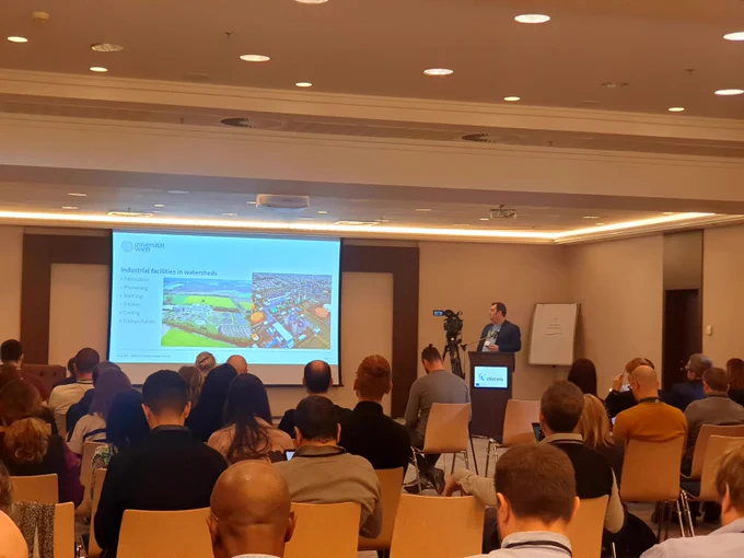 Atakan Aral presents about SWAIN project's success story in open science at the CHIST-ERA project seminar 2023 in Bratislava. The slide shows the industrial facilities in watersheds.