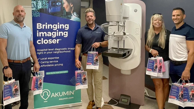 Akumin team members in front of a 3D Mammo unit.