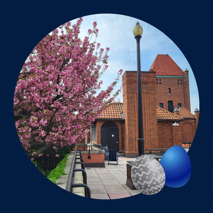 On top of a dark blue background is a springtime photo of Car Barn patio in a circular frame with a pink blooming tree on the left and red brick building on the right; a gray and blue Easter egg are in the bottom right