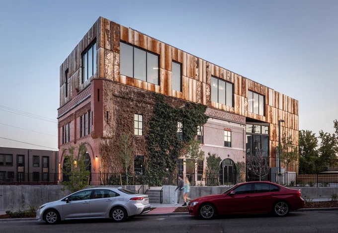 Three story rectangular building with cars in front