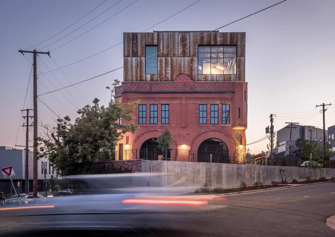 Three-story mostly brick building at dusk