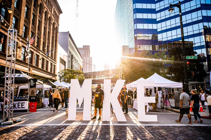 Milwaukee street market with big letters in street that say MKE