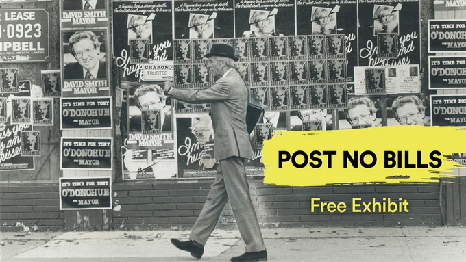 Black and white photo of man walking past busy wall of street posters and superimposed text reading Post No Bills Free Exhibit