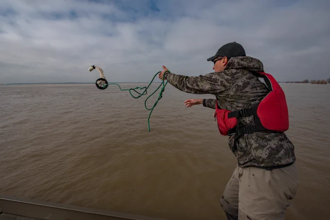 Throwing a zooplankton net into a floodplain; the net is in mid-swing.