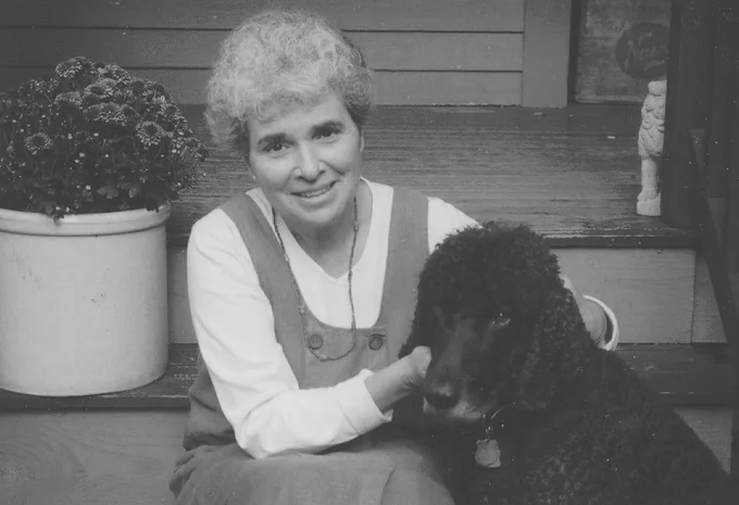 Joan Bolker sitting on stairs with her dog.