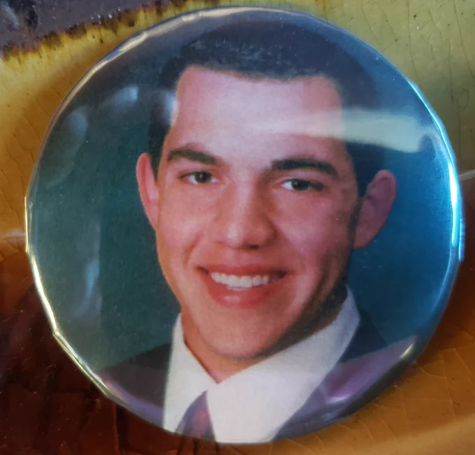 A button with a smiling man on it.