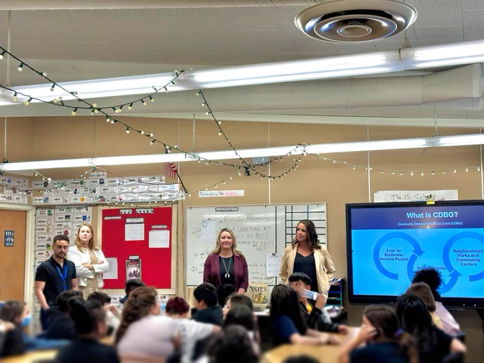Three team members addressing a group of 5th graders 
