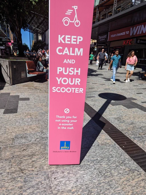 Sign in a pedestrian mall reading 'Keep Calm and Push Your Scooter'