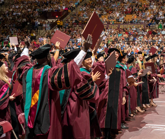 TXST doctoral students celebrating at graduation ceremony