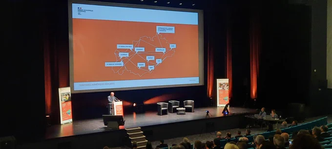 Scène de la salle de conférence avec carte du territoire numérique éducatif de l'Herault