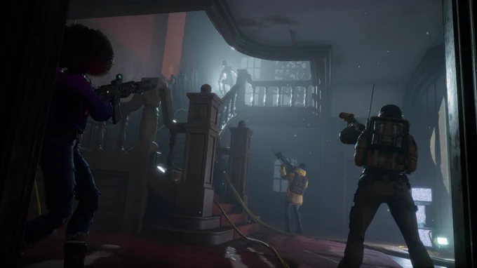 Image from Redfall set in a lived-in mansion that’s fallen into disrepair with a backlit vampire at the top of a wooden staircase with three heroes with their weapons at the ready staring up from the base of the stairs. 