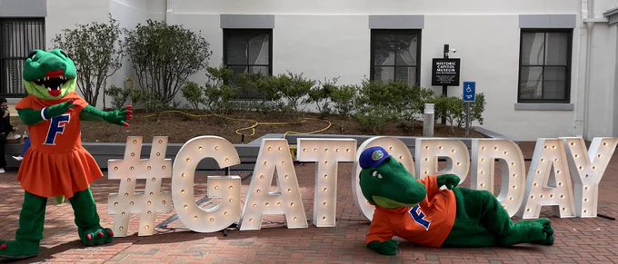 Albert and Alberta pose with giant #GATORDAY sign.