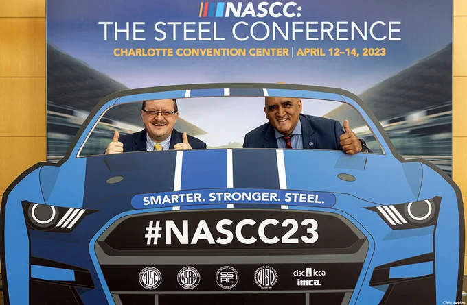 AISC President Charlie Carter and FHWA Administrator Shailen Bhatt giving thumbs up in a racecar photo booth