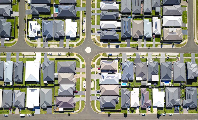 An aerial view of a neighborhood. It shows streets, different homes and properties.