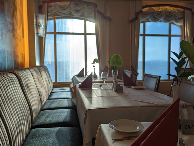 Speisesaal/Restaurant auf der Color Fantasy, leere Tische auf dei die Sonne aus großen Fenstern fällt 