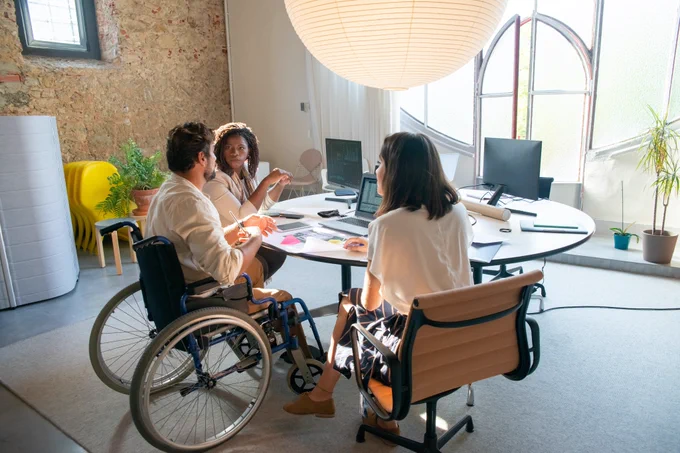 Image shows a group of people working at a desk