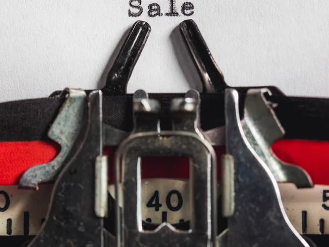 An image of a typewriter with the word: Sale. 
