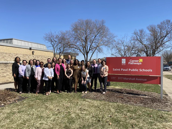 Large group posing in front of the Career Pathways Center of Saint Paul Public Schools