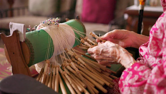 close-up of a woman's hands making lace 
