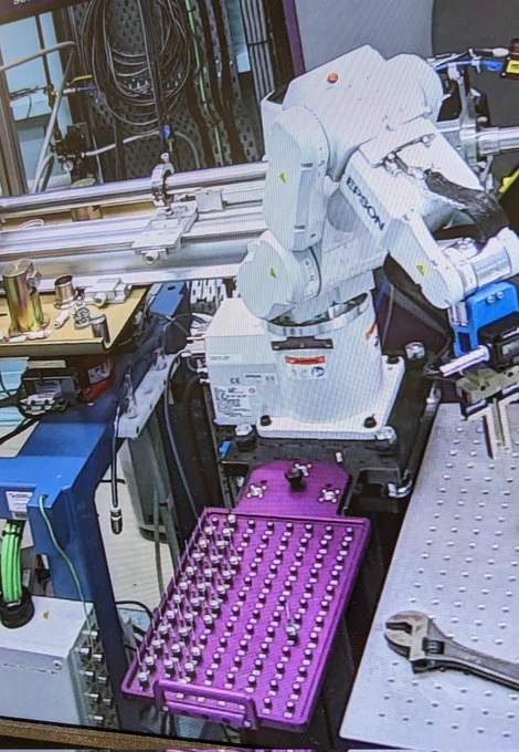A robot arm sat above a purple sample tray with various samples loaded and ready to go 