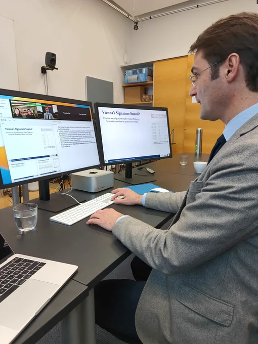 Prof. Dr. Werner Goebl presenting on a dual-monitor computer set-up via a Zoom teleconference session