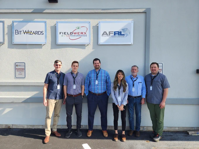 Mile two project team in front of a building