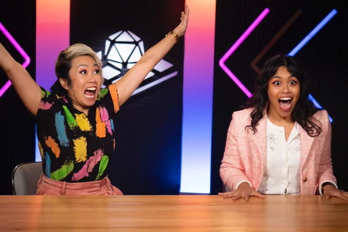 Michelle and Surena Marie looking very excited with arms raised and jaws dropped because the Tabletop News Kickstarter is 6% away at time of post