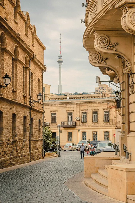 A photo of a city with yellow stone buildings and a cobbled street
