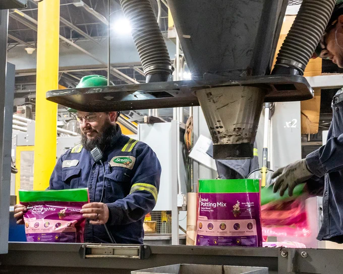 Associate filling bags of soil