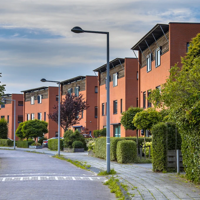 A photo of apartment buildings along a street.