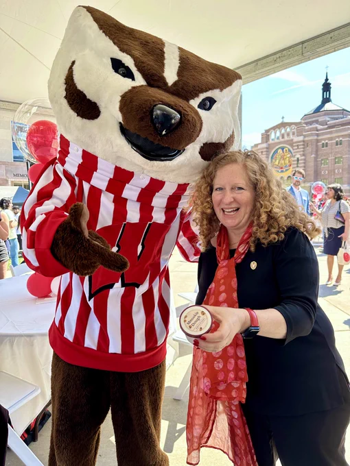 Photo of Bucky Badger and Chancellor Jennifer Mnookin holding a scoop of the newest flavor of Babcock Dairy ice cream, Mnookie Dough.
