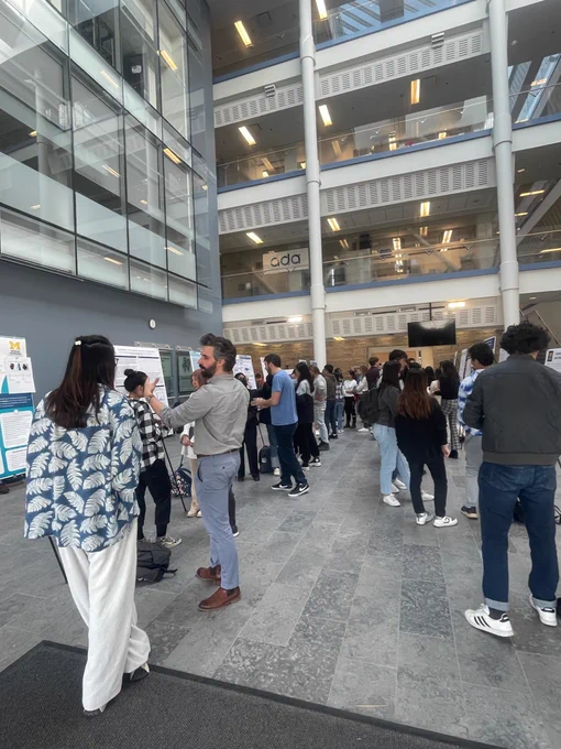 Zhe Che talks to Nikola Banovic in front of her poster showing Zhe's research.