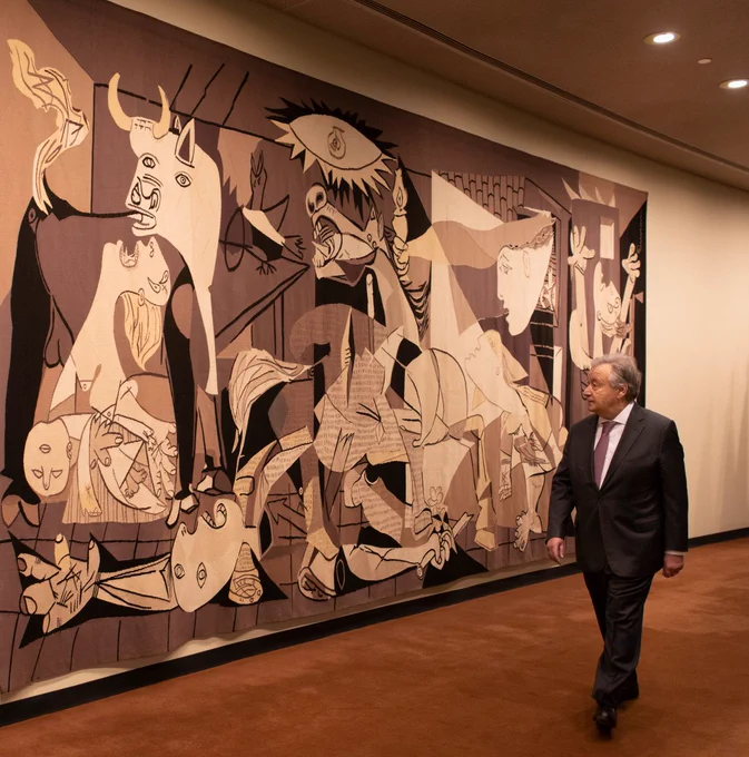 United Nations Secretary-General António Guterres walks by a wall tapestry depicting Picasso’s iconic Guernica painting. The tapestry is located outside the Security Council Chamber of the United Nations Headquarters in New York.

The canvas tapestry measures 10 by 22 feet and is a rendering of the original work that Pablo Picasso painted in 1937 during the Spanish Civil War.

With its motifs of people and animals suffering from the violence and chaos, it expresses the horrors of war.