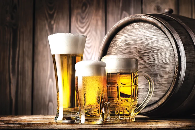Three beers on wooden background