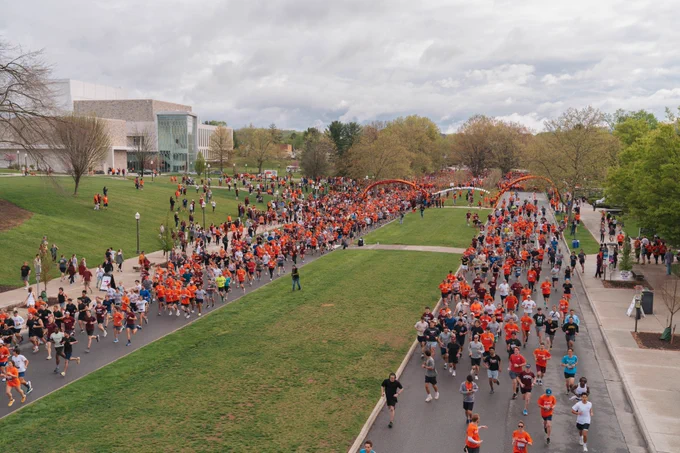 An overhead image depicts participants in the 3.2-Mile Run in Remembrance running down Alumni Mall.