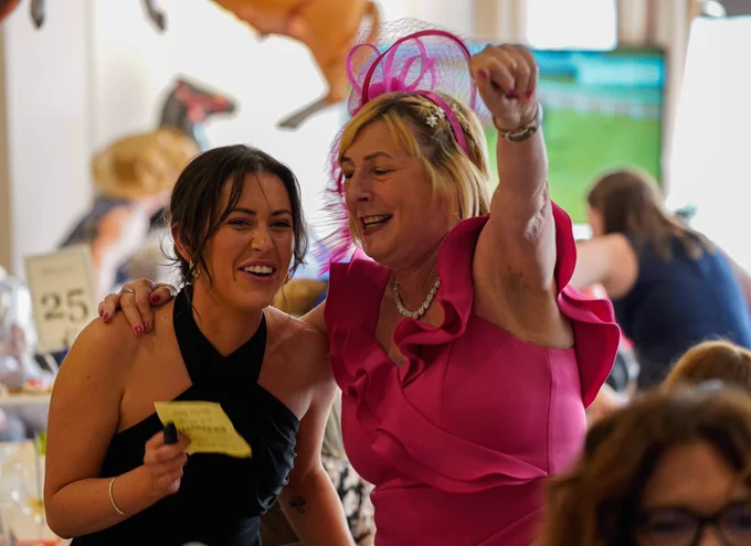 Two guests celebrating after a win at our Grand National fundraising event.