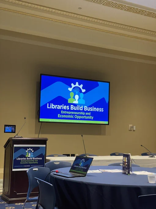 Picture of a slide at an ALA event that reads: Libraries Build Business, Entrepreneurship and Economic Opportunity.