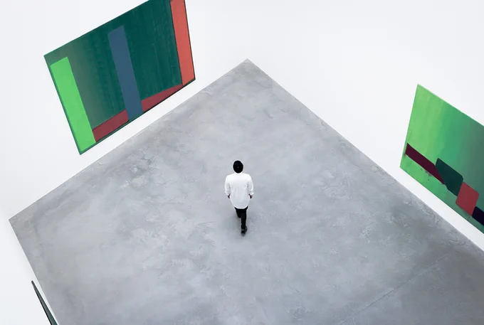 Image from above of a person standing alone in an art gallery