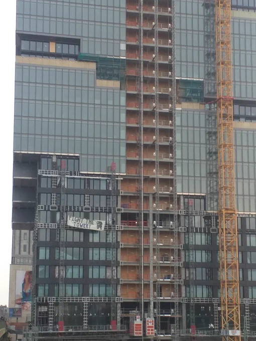 Das ist ein Baustellen Foto vom Amazon Tower. Aktivisten sind auf dem Tower geklettert und haben ein Banner eingehängt mit der Aufschrift Fight the tower.