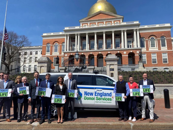 Group holding Donate Life signs in front of MA state house