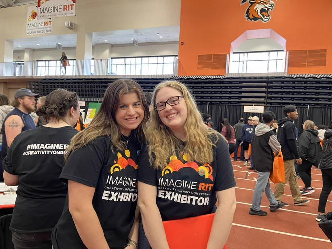 Two students in black shirts smiling
