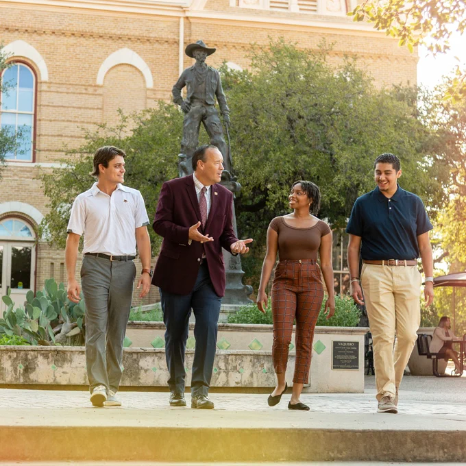 Student walking with President Damphousse