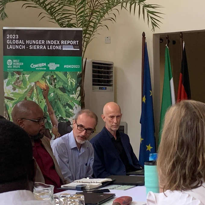 Stefano Temporin - Country Director @WHHSLE  (on the right), Austin Kennan - Country director Sierra Leone @concern (centre) & Gospel Matondi -  Programm Director at @WHHSLE (on the left) listeing to an intervention at the launch of Global Hunger Index Report 2023 on 18 April 2023 at the German Residence in Freetown.
In the back the official banner of the Global Hunger Index Report (on the left) and the European, Sierra Leonean and German flags (from left to right - on the right.)

(c) German Embassy

(c) German Embassy