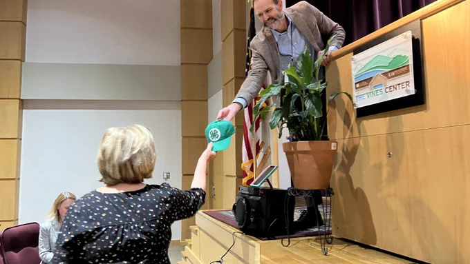 Woman gets 4H hat from Bob Scott.